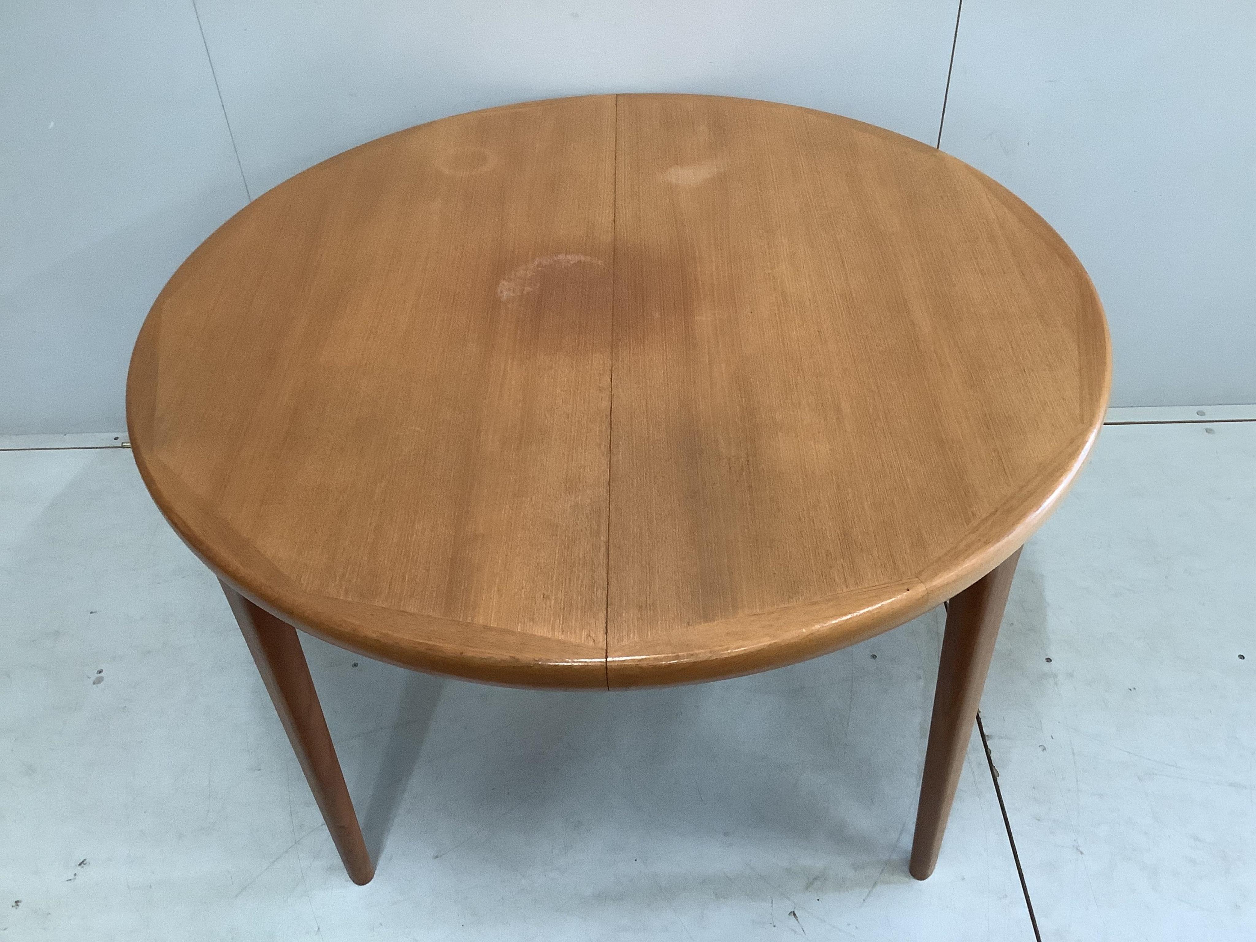A mid century teak oval extending dining table, width 220cm extended, two spare leaves, depth 120cm, height 72cm and six chairs
